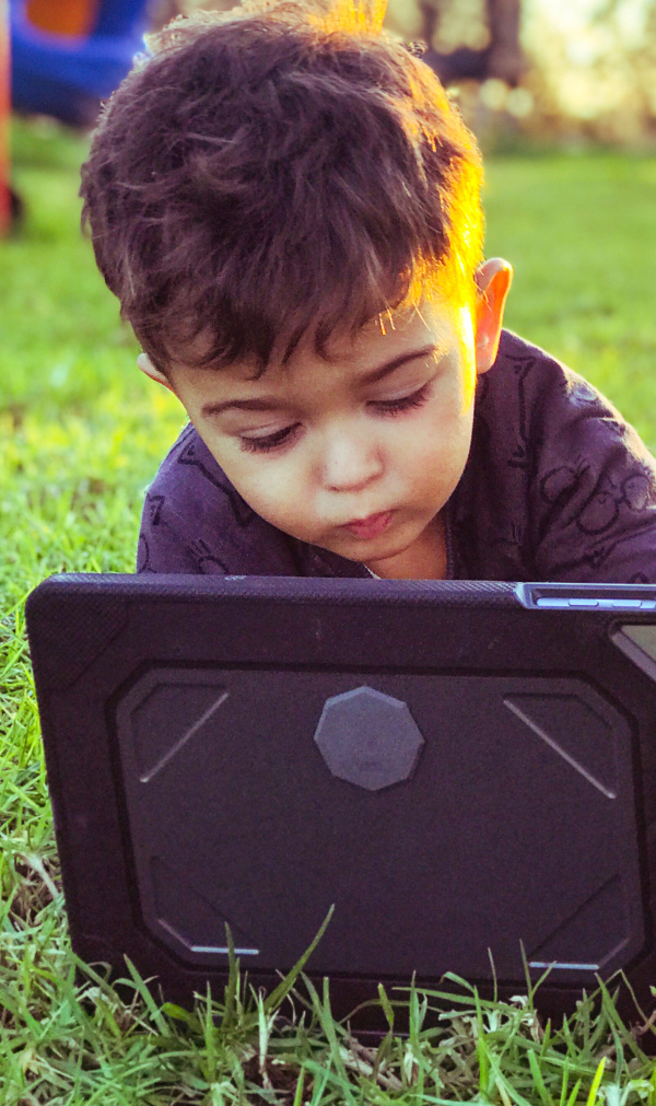 A kid watching exploring laptop with coMra Wave attached