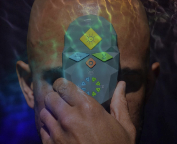 A coMra device held to the forehead, from the Science to Sage Magazine cover